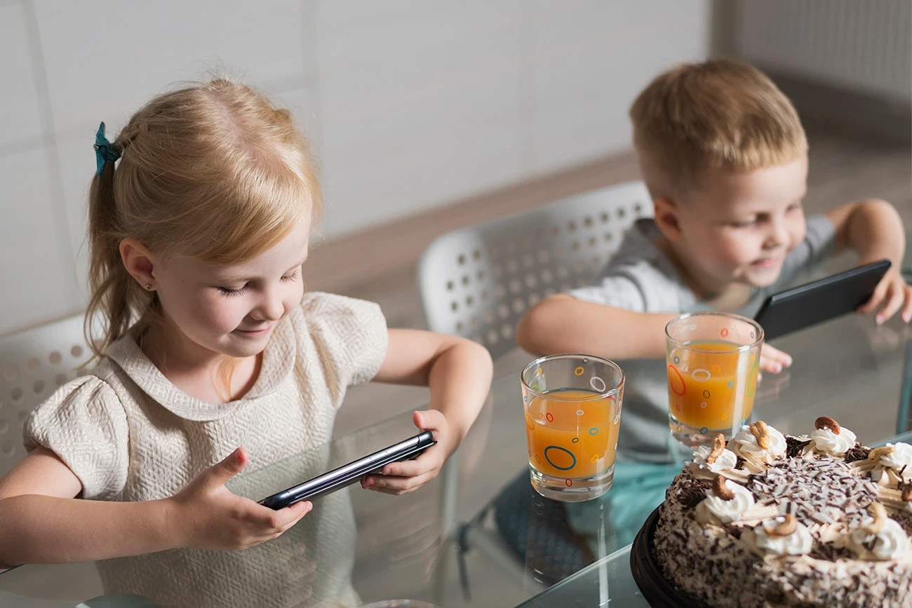 deux enfants en train d'utiliser un smartphone